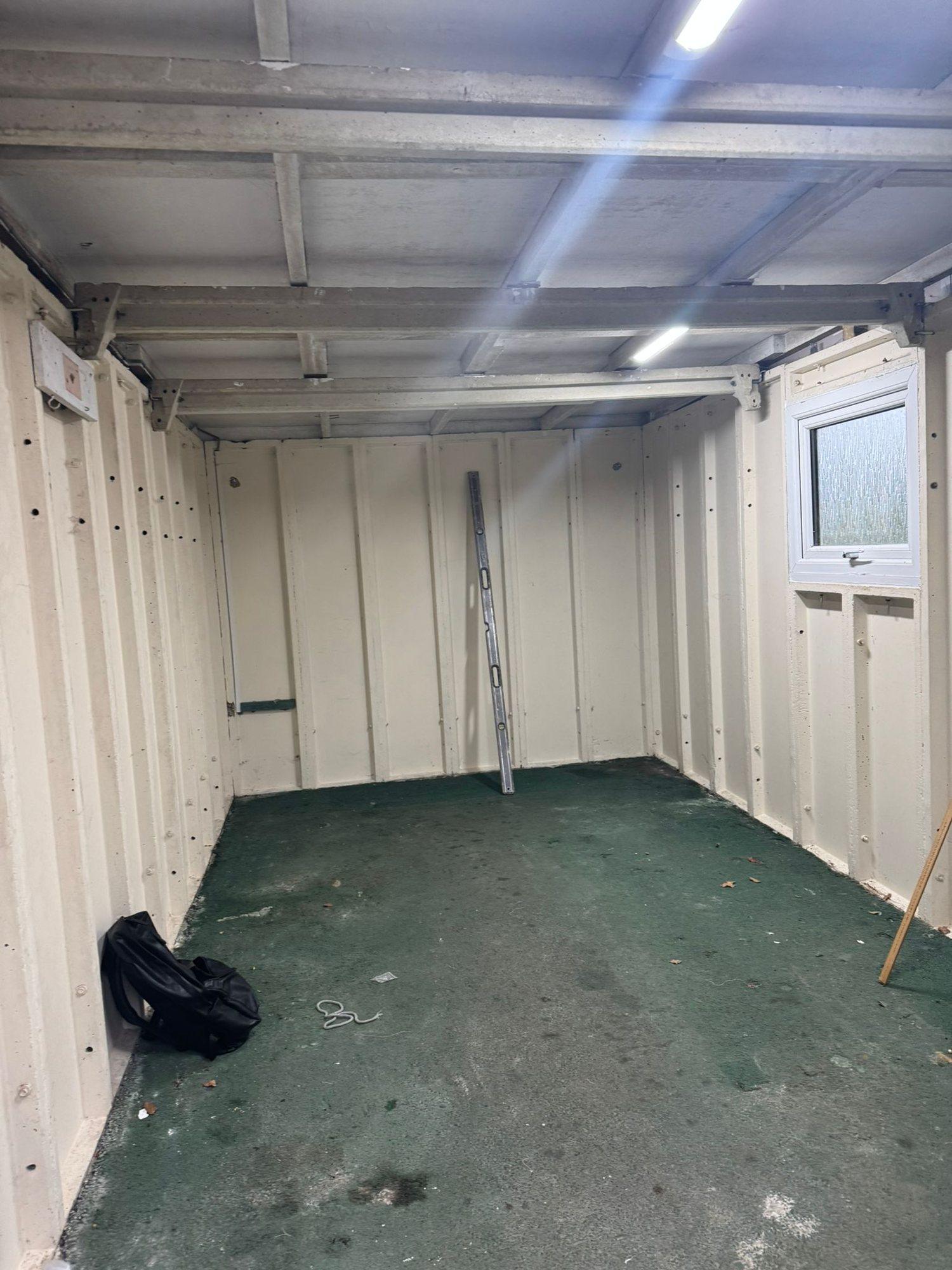 The detached garage before: exposed steel frame and bare floor